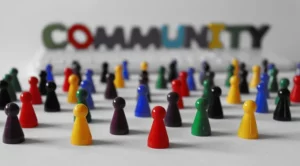 Pions de couleur rassemblés devant le mot « community »