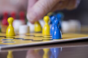 Main déplaçant des pions jaunes et bleus sur un plateau