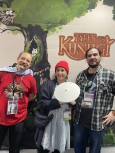 Visiteurs posant devant un stand du Festival International des Jeux